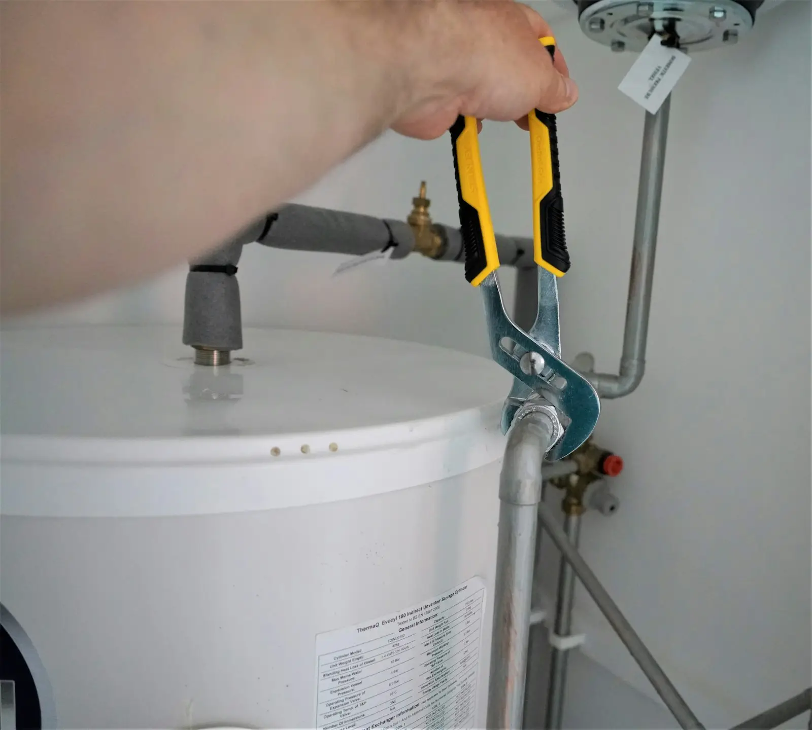 A new hot water cylinder installed in an airing cupboard