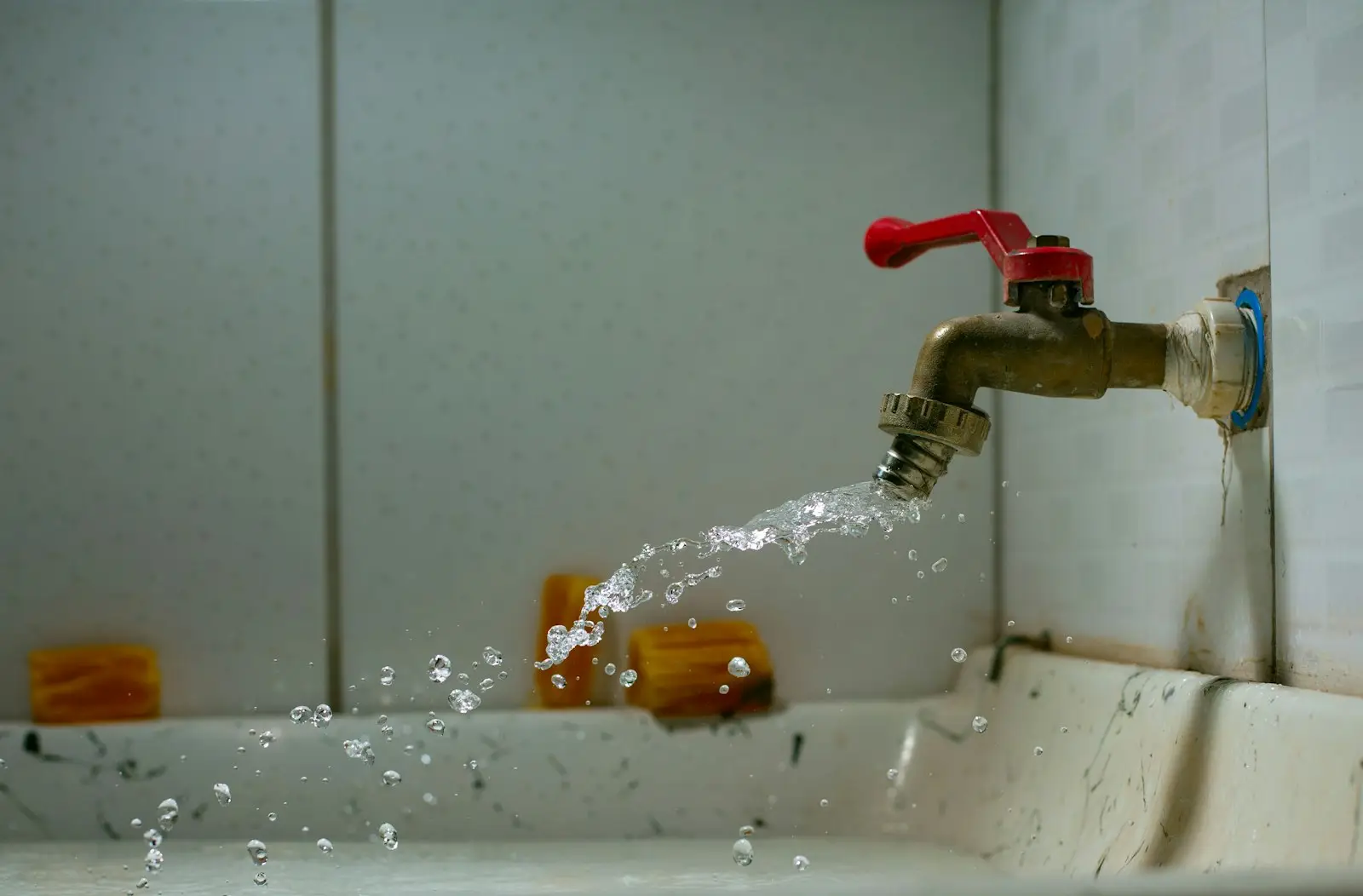 A close-up of a leaking pipe joint dripping water