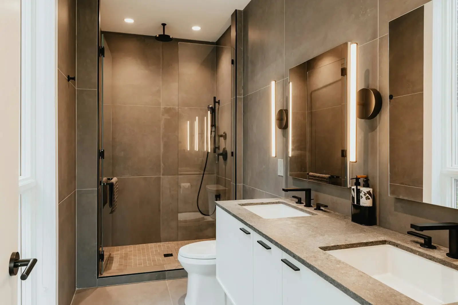 A modern bathroom with a white bath and tiled walls