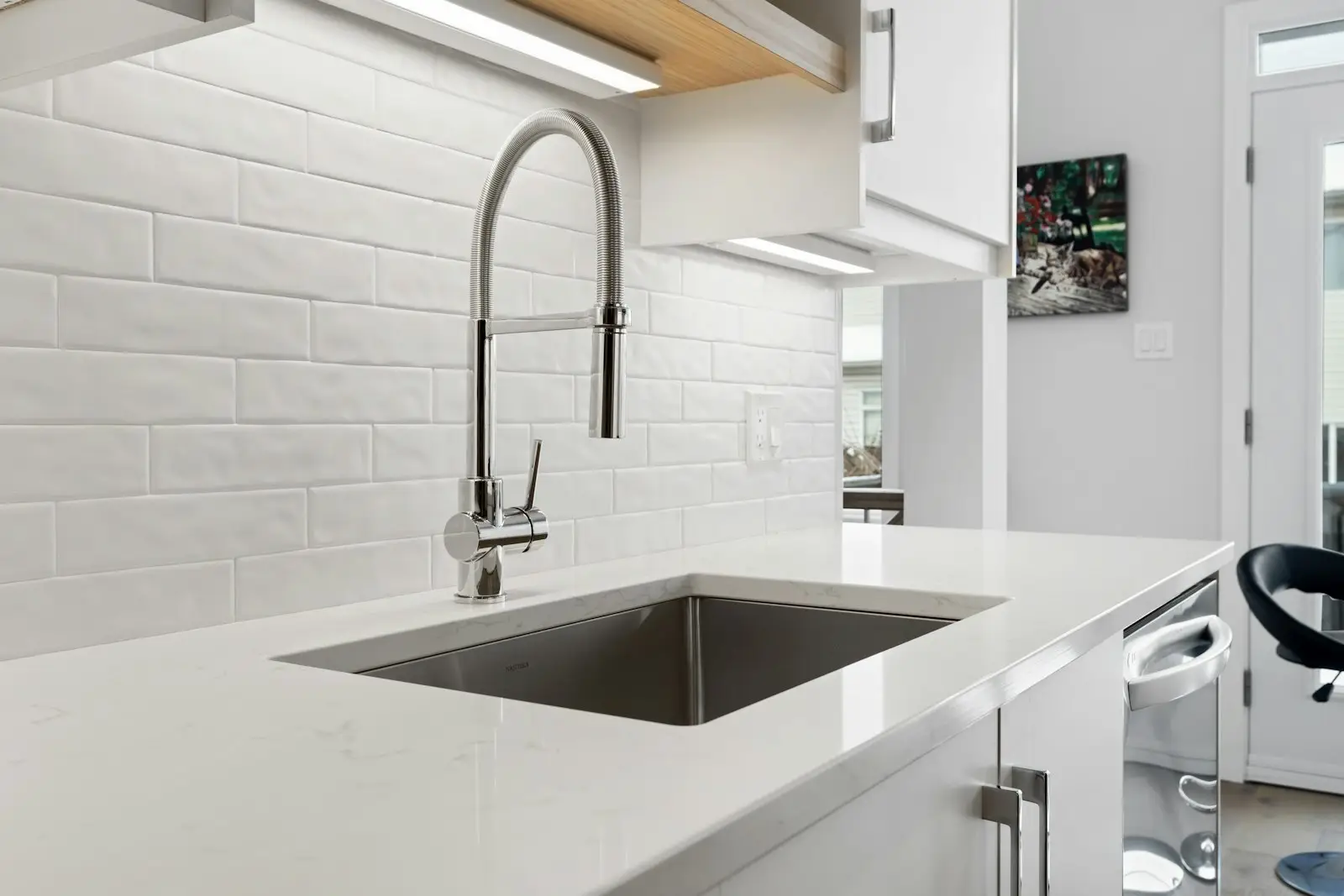 A kitchen sink with a modern chrome tap