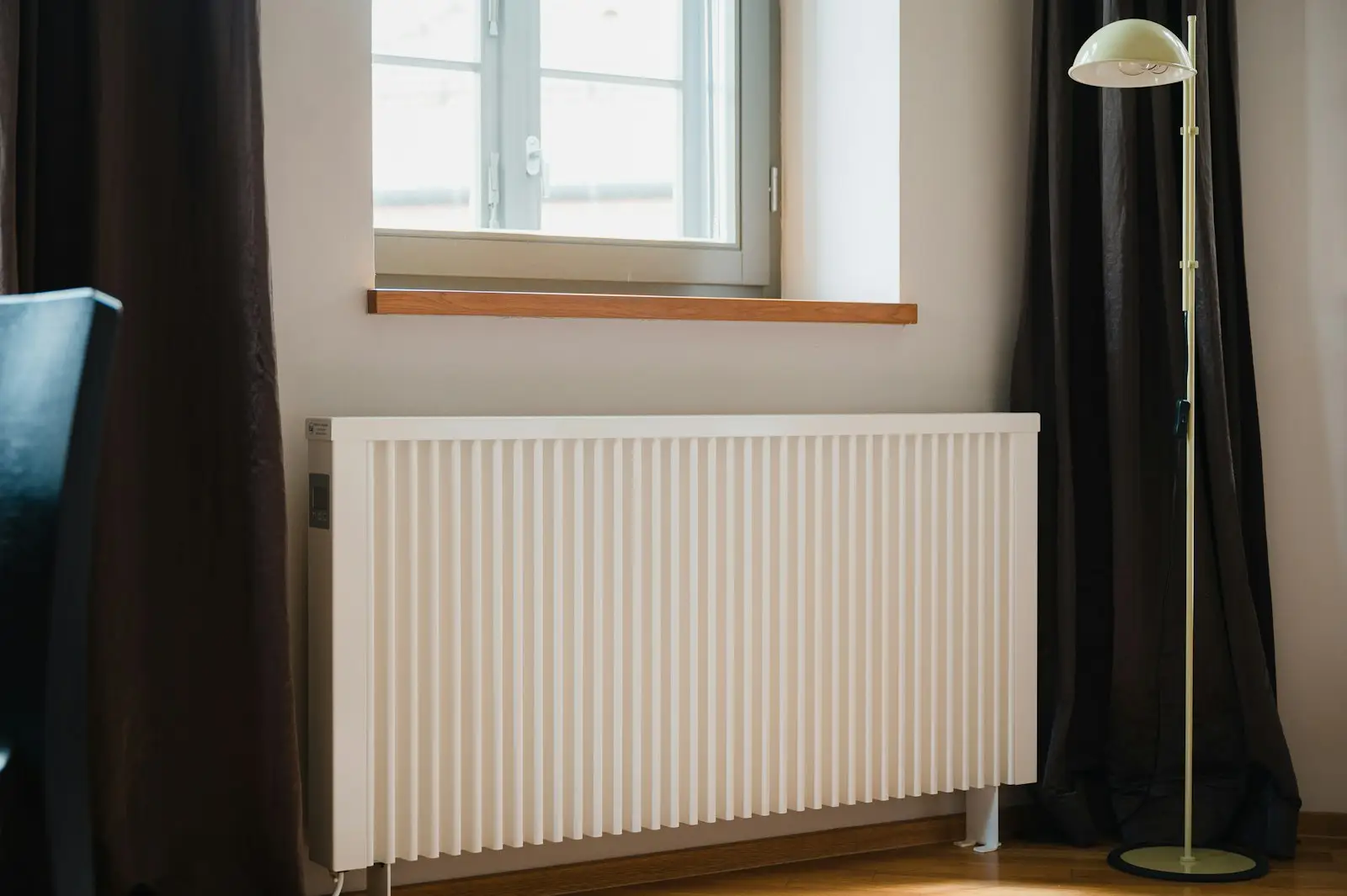 A white radiator fitted under a window